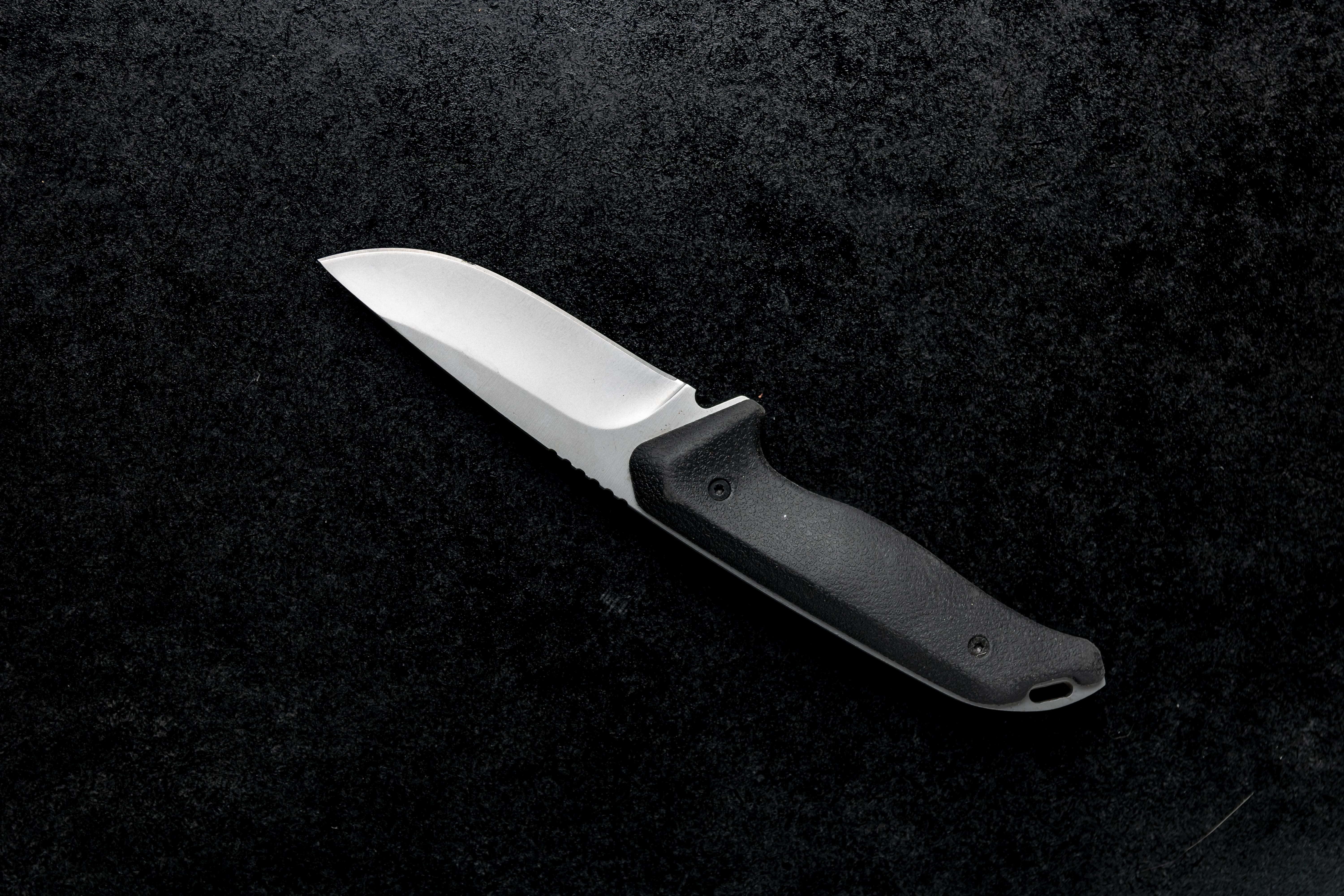 closeup-shot-small-combat-knife-with-black-handle-table