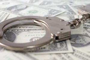 closeup-view-metal-handcuffs-dollars