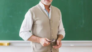 senior-male-teacher-with-glasses-against-chalkboard (1)