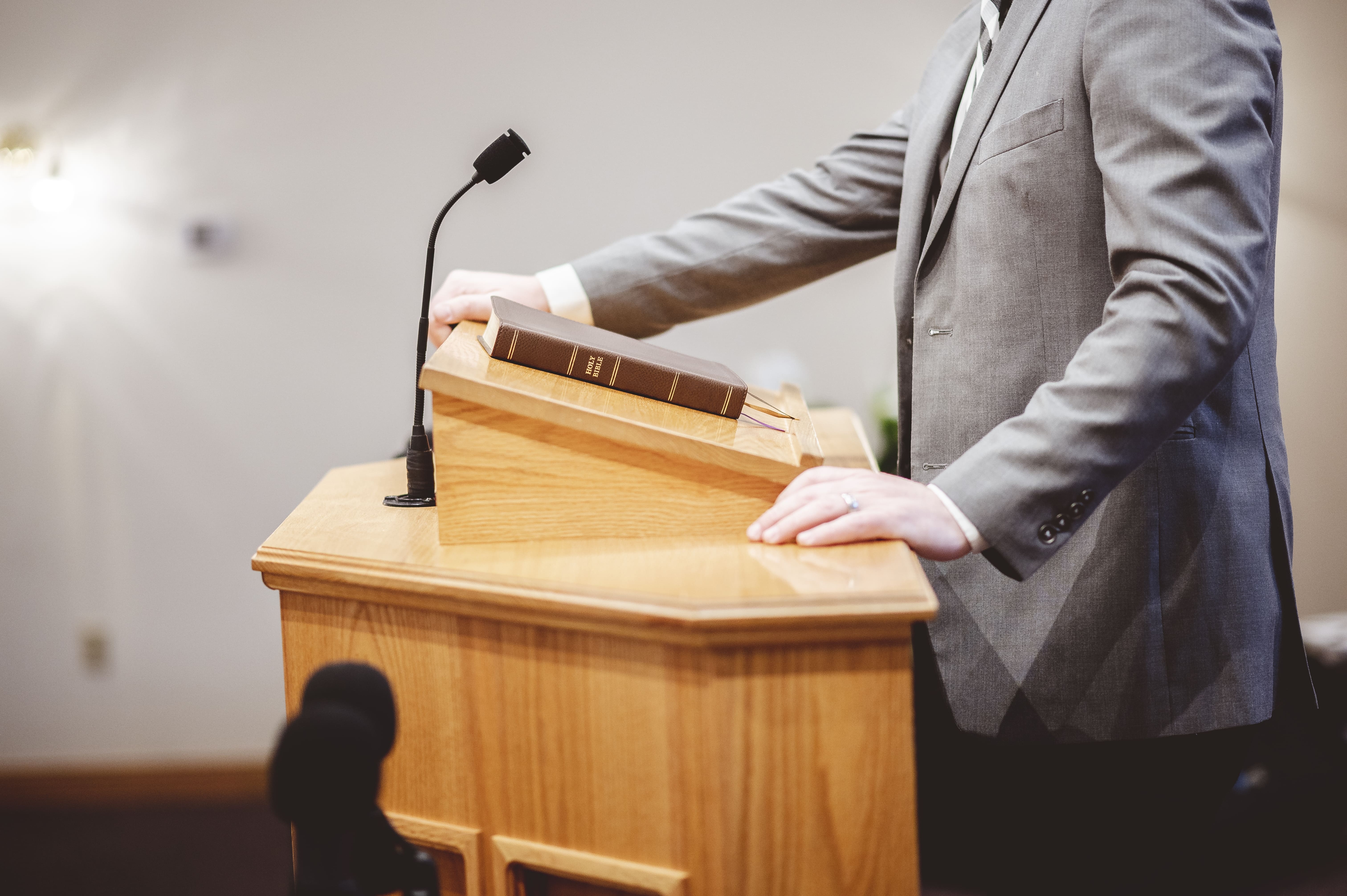 selective-focus-shot-male-standing-speaking-from-pulpit (1)